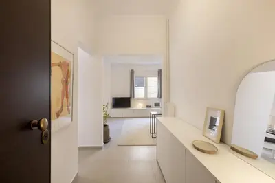 a white living room with a white counter and a mirror at Kerameikou25 large in Athens