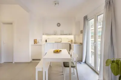 a white kitchen with a white table and chairs at Kerameikou25 large in Athens