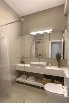 a bathroom with a sink and a toilet and a mirror at Kerameikou25 large in Athens
