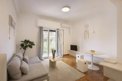 a white living room with a couch and a table at Kerameikou25 small in Athens