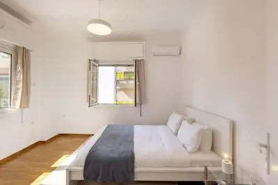 a white bedroom with a bed and a couch at Kerameikou25 small in Athens