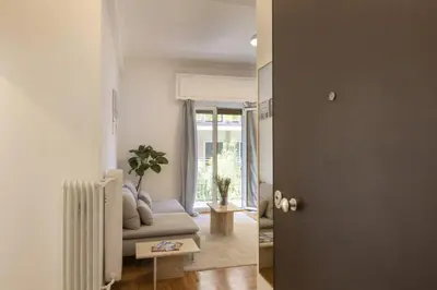 a living room with a couch and a door at Kerameikou25 small in Athens