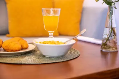 a bowl of cereal and a glass of orange juice on a table at Harmony - Brand New Airport Apt. in Spáta