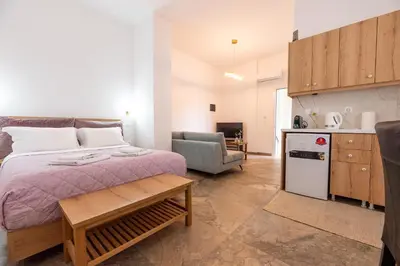 a small bedroom with a bed and a kitchen at Harmony - Brand New Airport Apt. in Spáta