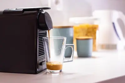 a glass of coffee is sitting next to a toaster at Harmony - Brand New Airport Apt. in Spáta
