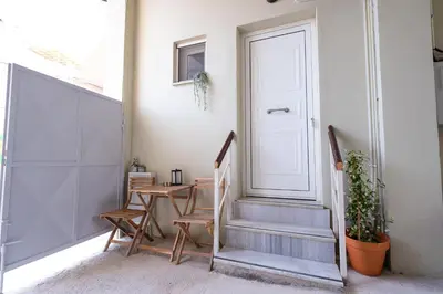a hallway with stairs and a door and a table at Harmony - Brand New Airport Apt. in Spáta