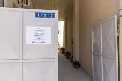 a door with a sign on it next to a building at Harmony - Brand New Airport Apt. in Spáta