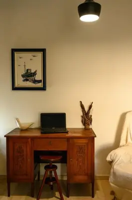 a desk with a laptop on it next to a bed at Quiet Family apartment with Garden and Balconies in Athens