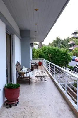 a porch with benches and chairs on a balcony at Quiet Family apartment with Garden and Balconies in Athens