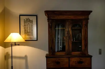 a wooden cabinet in the corner of a room with a lamp at Quiet Family apartment with Garden and Balconies in Athens