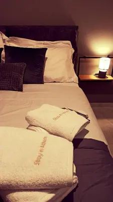 a bed with two white towels on it at Stay in Athens - muses in Athens