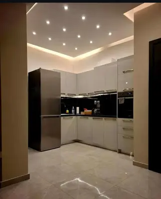 a kitchen with white cabinets and a black refrigerator at Stay in Athens - muses in Athens