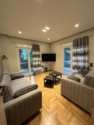 a living room with two couches and a flat screen tv at Coastal Harmony Alimos in Athens
