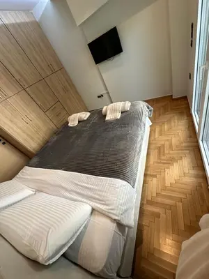 a large bed in a room with wooden floors at Coastal Harmony Alimos in Athens
