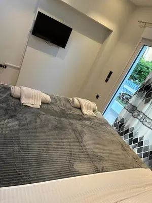 a bedroom with a large bed with a flat screen tv at Coastal Harmony Alimos in Athens