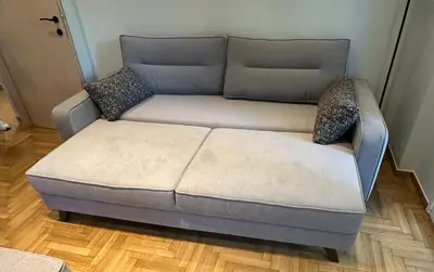 a gray couch with pillows on a wooden floor at Coastal Harmony Alimos in Athens