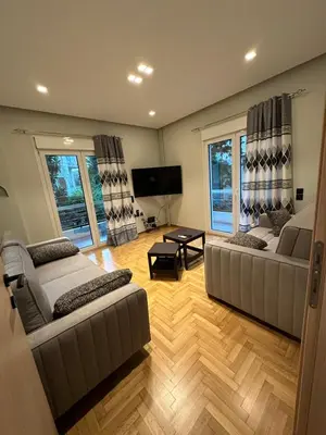a living room with two couches and a flat screen tv at Coastal Harmony Alimos in Athens