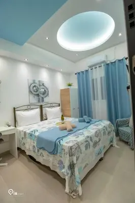 a bedroom with a large bed with blue curtains at The Aqua - Stylish & Comfy Studio in Egaleo-Athens in Athens
