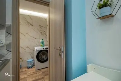a bathroom with a washing machine next to a door at The Aqua - Stylish & Comfy Studio in Egaleo-Athens in Athens