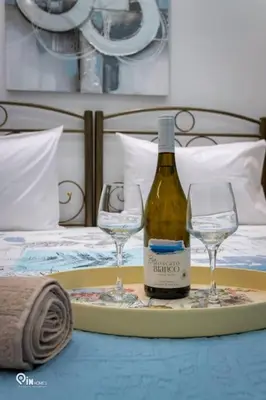 a tray with a bottle of wine and two glasses on a bed at The Aqua - Stylish & Comfy Studio in Egaleo-Athens in Athens