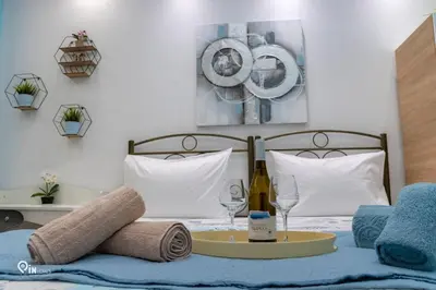 a bed with a table with a bottle of wine and glasses at The Aqua - Stylish & Comfy Studio in Egaleo-Athens in Athens