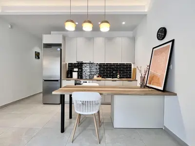 a kitchen with a table and a refrigerator at Chic Getaway Near Stavros Niarchos in Athens