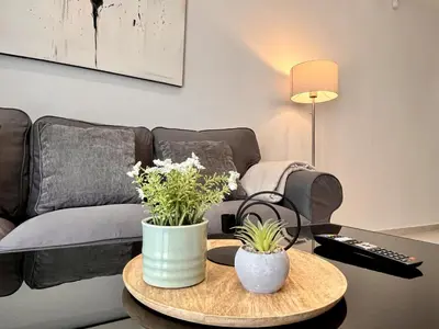 a living room with a couch and a table with flowers at Chic Getaway Near Stavros Niarchos in Athens