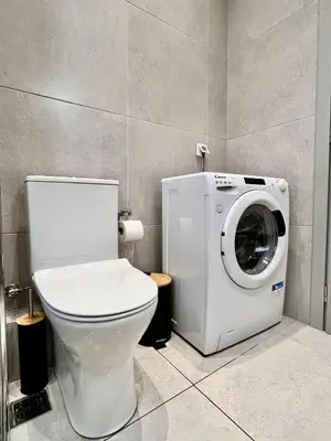 a bathroom with a toilet and a washing machine at Chic Getaway Near Stavros Niarchos in Athens