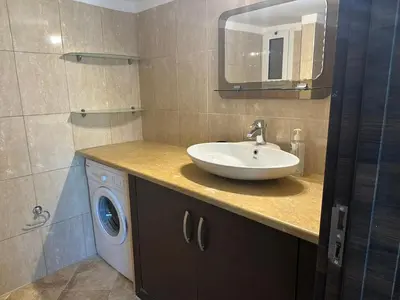 a bathroom with a sink and a washing machine at Riviera Beach apart no 5 in Anavissos