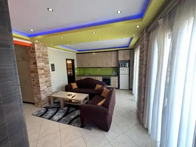 a living room with a couch and a table at Riviera Beach apart no 5 in Anavissos