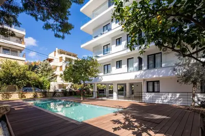 an apartment with a swimming pool in front of a building at Athens Sea Side Escape in Vari