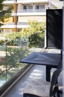a table and a chair on a balcony at Athens Sea Side Escape in Vari
