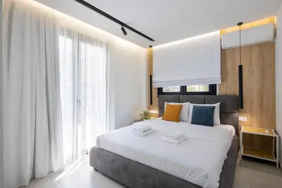 a bedroom with a large bed and a large window at Athens Sea Side Escape in Vari