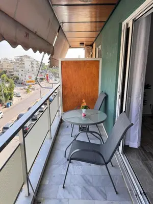 a table and chairs on the balcony of a building at South coast -- AL020 in Athens