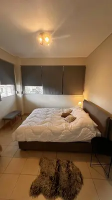 a bedroom with a bed with a furry rug on it at Koropi 3 bedroom Luxurious Apartment 5 pers- Angel House in Koropíon