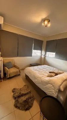 a bedroom with a bed and a chair and a rug at Koropi 3 bedroom Luxurious Apartment 5 pers- Angel House in Koropíon
