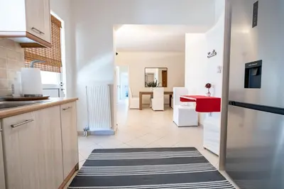 a kitchen with a refrigerator and a red table at Koropi 3 bedroom Luxurious Apartment 5 pers- Angel House in Koropíon
