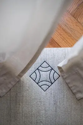 a white rug with a diamond on it on a floor at Honey in Athens