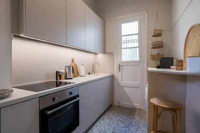 a kitchen with white cabinets and a sink and a stove at Honey in Athens