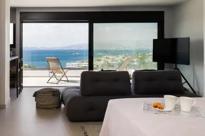 a living room with a couch and a view of the ocean at Experience Penthouse by Athens Riviera Suites in Saronida