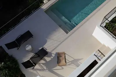 an overhead view of a swimming pool with two chairs and a table at Experience Penthouse by Athens Riviera Suites in Saronida