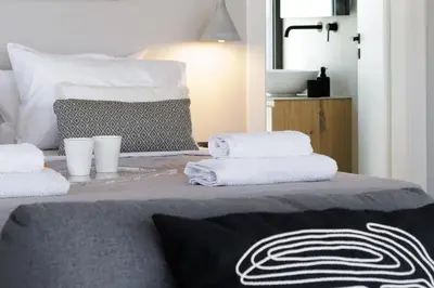 a bed with towels and cups on top of it at Experience Penthouse by Athens Riviera Suites in Saronida