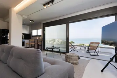 a living room with a couch and a large window at Experience Penthouse by Athens Riviera Suites in Saronida