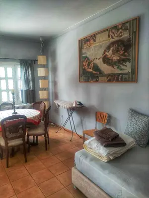 a living room with a couch and a table and a painting at Home4U, just 7km from airport in Markopoulo