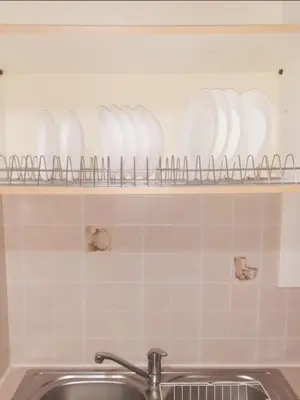 a shelf above a sink with dishes on it at A-Apartments -- Agiou Therapontos in Athens
