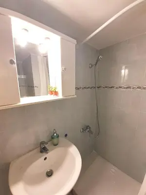 a white bathroom with a sink and a mirror at A-Apartments -- Agiou Therapontos in Athens