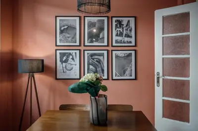 a vase of flowers on a table with pictures on the wall at Rouge in Athens