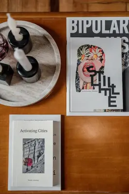 a table with two pictures and a book and some objects at Rouge in Athens