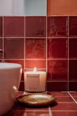 a candle sitting on a counter next to a tiled wall at Rouge in Athens
