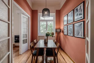 a dining room with orange walls and a table and chairs at Rouge in Athens